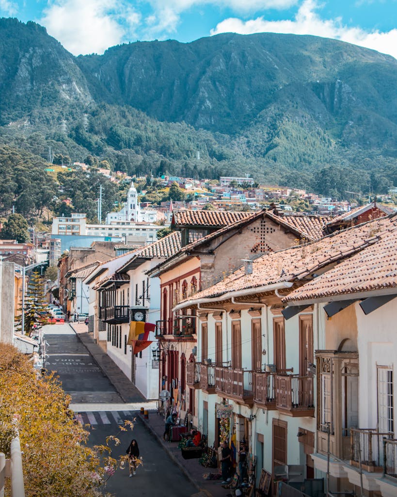 Explore a vibrant colonial street in Bogotá with stunning mountain views and colorful architecture.